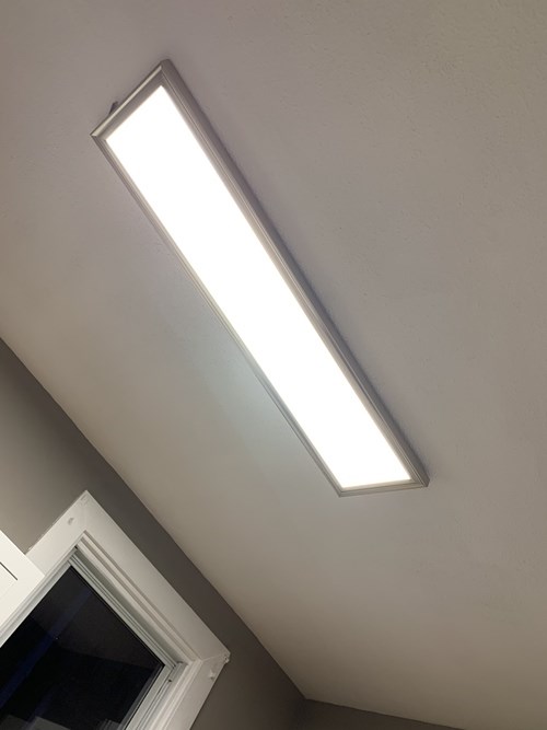 A long rectangular fluorescent light fixture is mounted on a white ceiling.