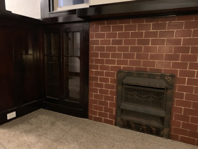 A fireplace in a room with a brick wall.