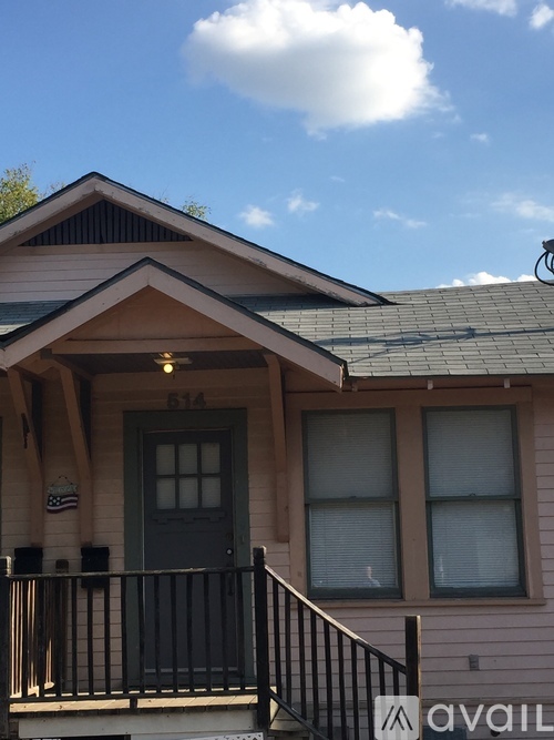 A house with a black door and a balcony with a railing.