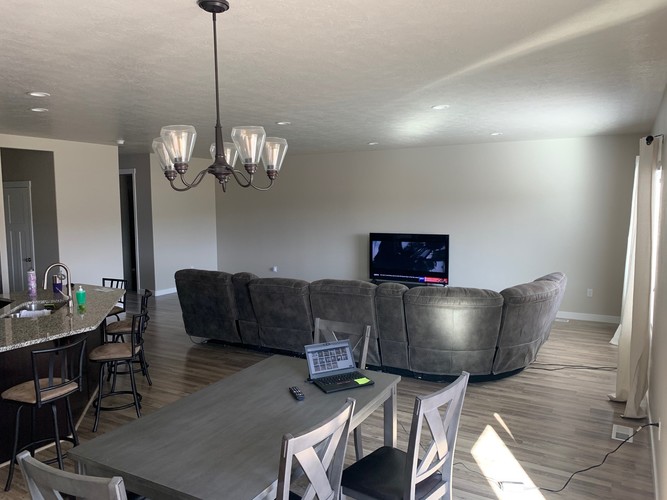 A modern living room with a grey couch and a wooden dining table.