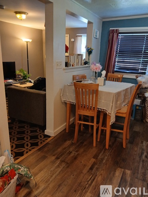 A kitchen with white cabinets and a window with curtains.