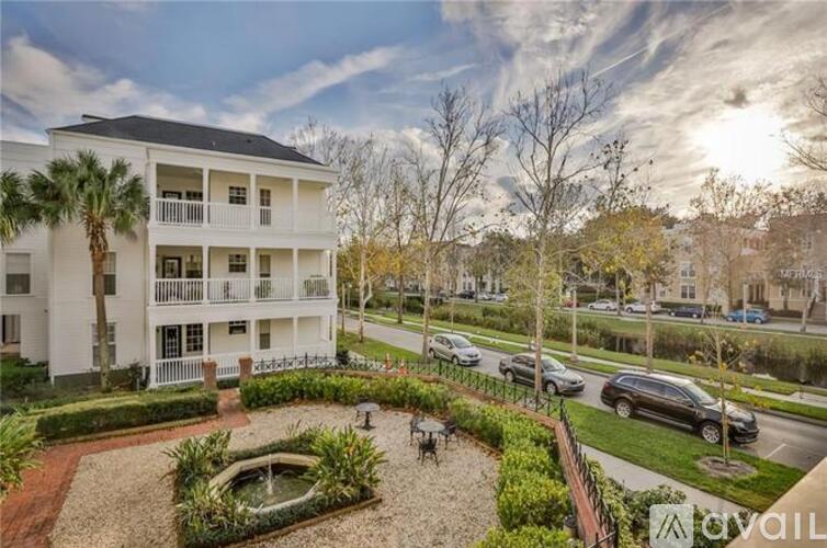 A white apartment building with a courtyard in front.
