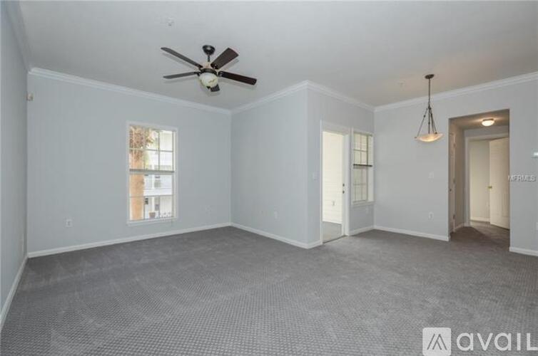 A spacious room with a ceiling fan and carpeted floor.