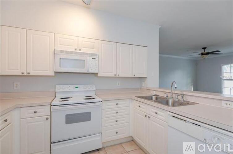 A kitchen with white appliances and cabinets.