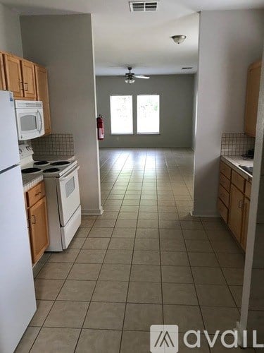 A kitchen with white appliances and wooden cabinets.