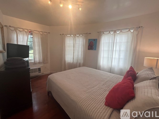 A bedroom with a large bed and a television.