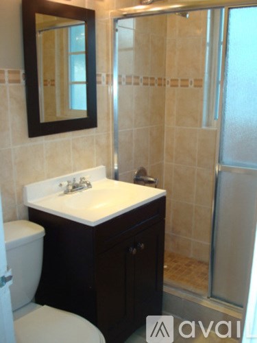 A bathroom with a toilet, sink and shower.