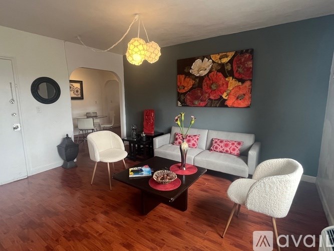 A living room with a white sofa, a coffee table, and a chandelier.