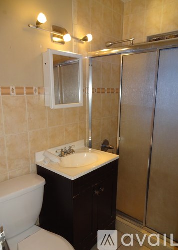 A bathroom with a toilet, sink, and shower.