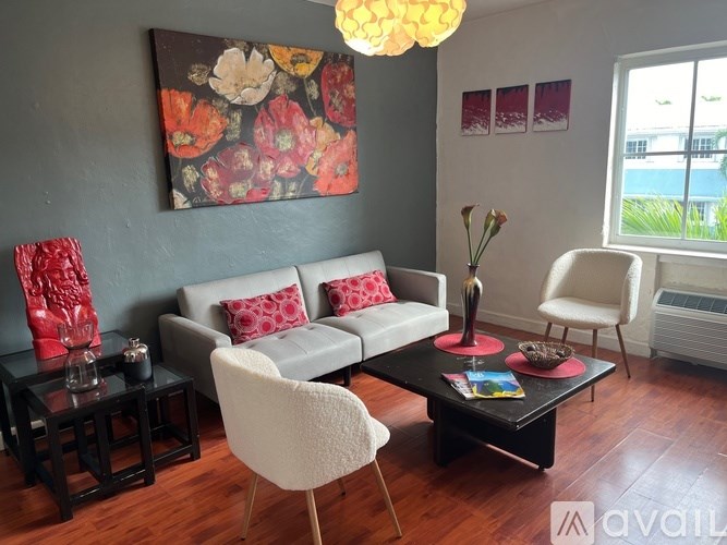 A living room with a grey couch, a white chair, and a black coffee table.