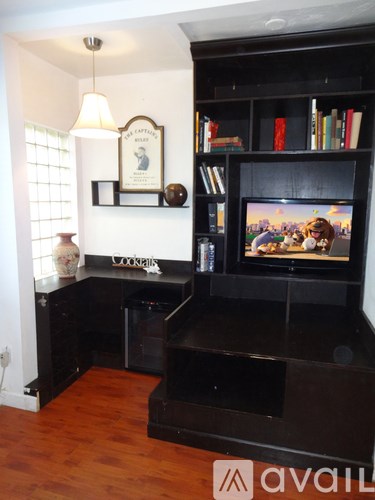 A black entertainment center with a television on it.
