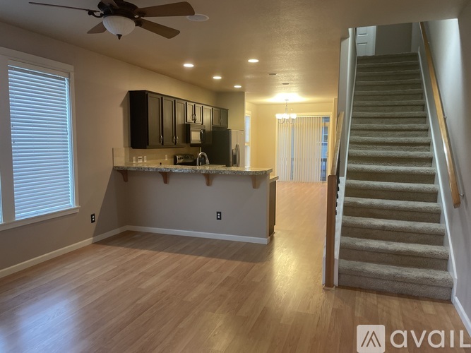 A spacious living room with a staircase leading to the upper floor.