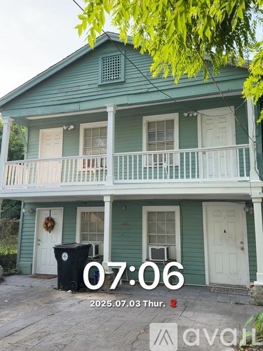 A two-story house with a front porch and a fence.