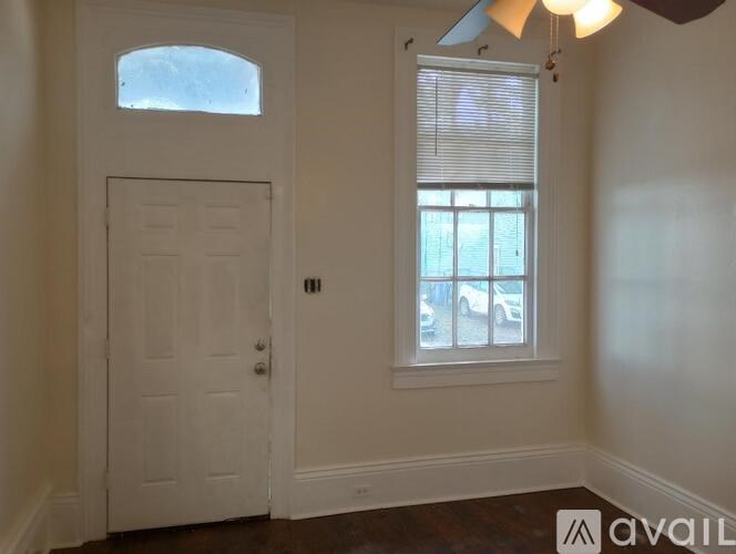 A room with a white door and a window with blinds.