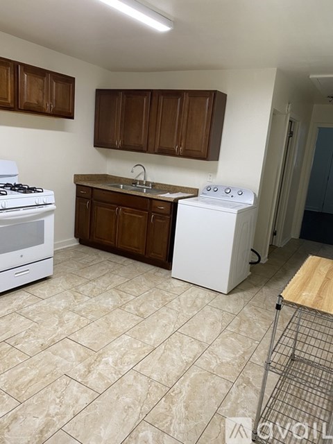 A kitchen with a white stove and a white dishwasher.