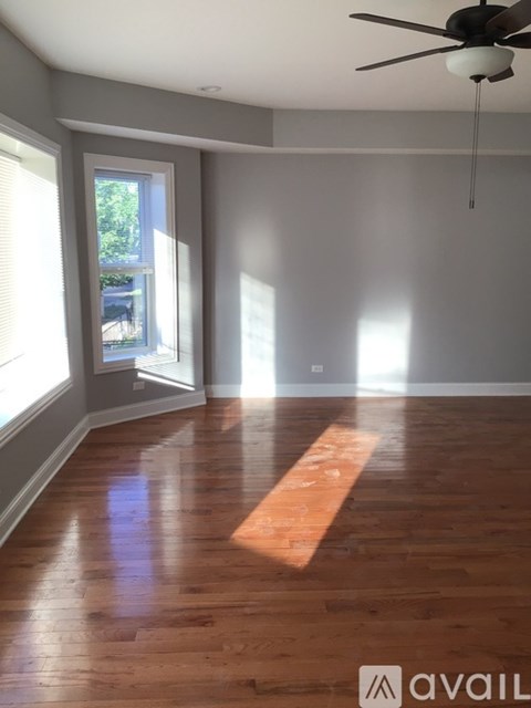 A room with wooden floors and a ceiling fan.