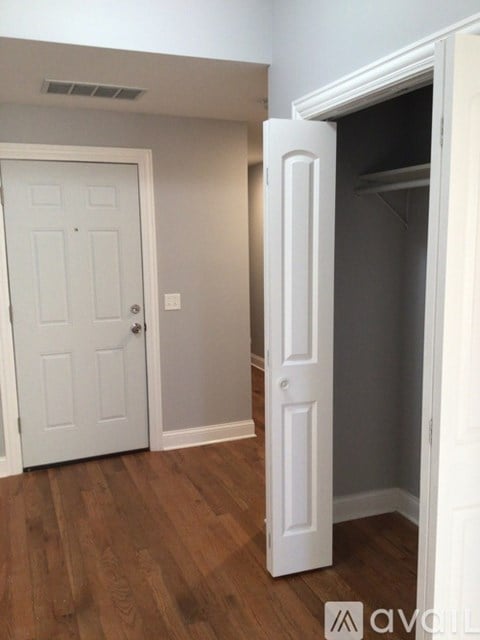 A white door is open to a dark room.