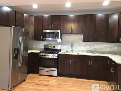 A kitchen with wooden cabinets and a stainless steel refrigerator.