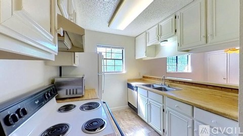 A kitchen with a stove top oven and a sink.