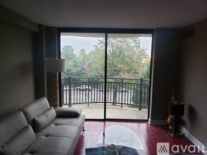 A living room with a grey sofa and a glass table.