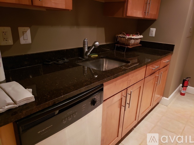 A kitchen with brown cabinets and black countertops.