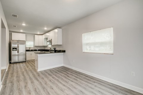 A kitchen with white cabinets and a refrigerator.