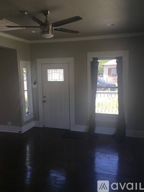 A room with a ceiling fan and a door.