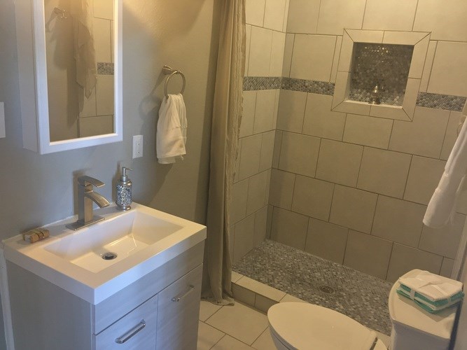 A white sink with a silver faucet is on a white cabinet in a bathroom.
