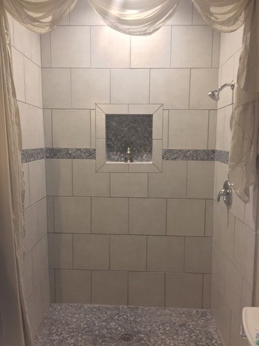 A bathroom with a shower and a window.