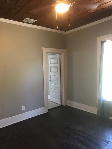 A room with a white door and a window with white curtains.
