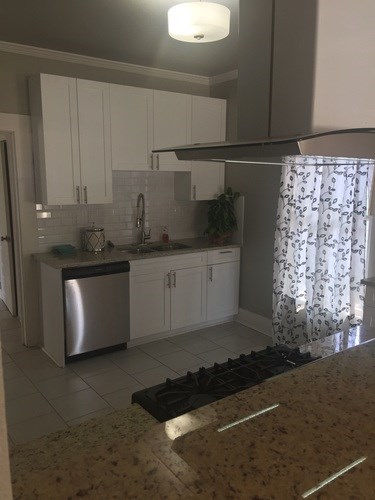 A kitchen with granite countertops and white cabinets.