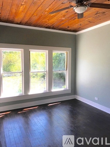 A room with wooden floors and a ceiling fan.