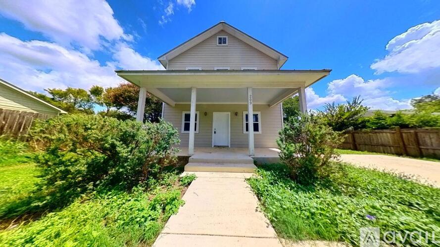 A house with a front yard and a clear sky.