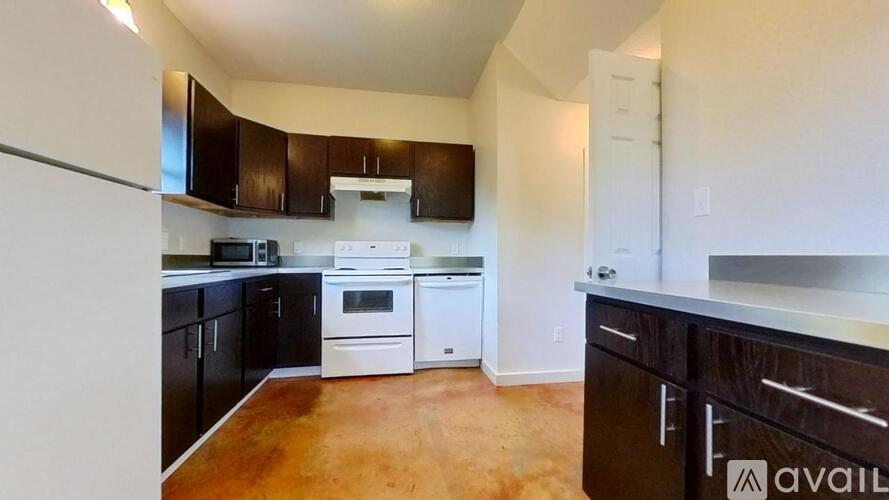 A kitchen with black cabinets and white appliances.