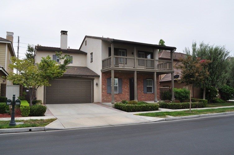 A two-story house with a garage and a balcony.
