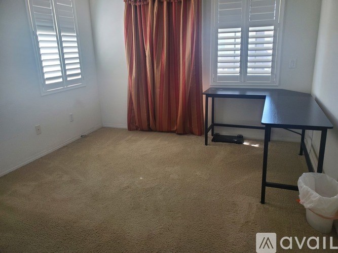 A room with a desk and a curtain.