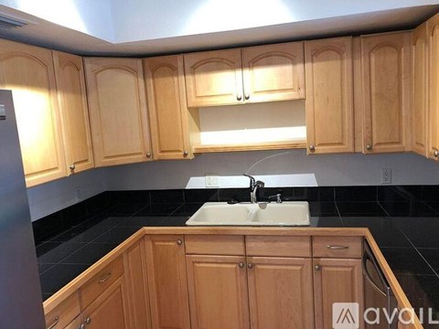A kitchen with wooden cabinets and a black countertop.