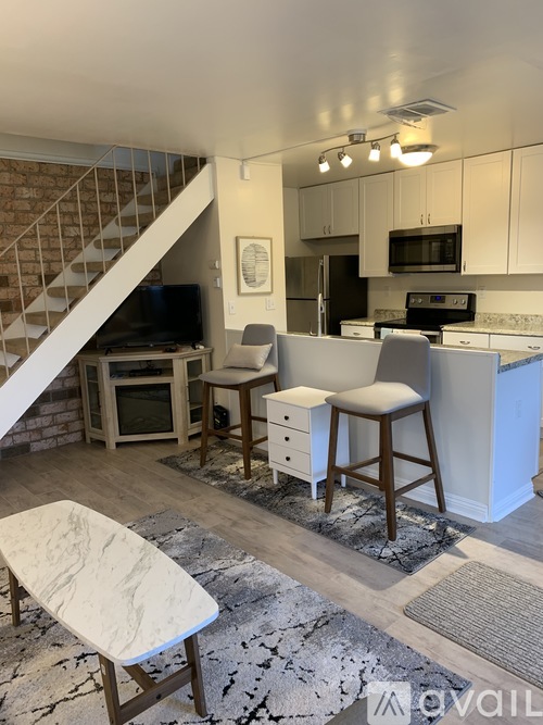 A kitchen with a white counter and a white chair.