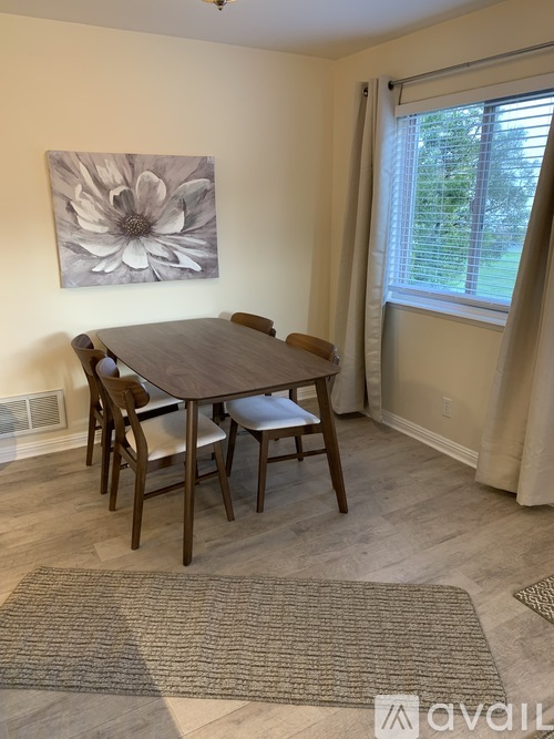 A dining room with a table and chairs.