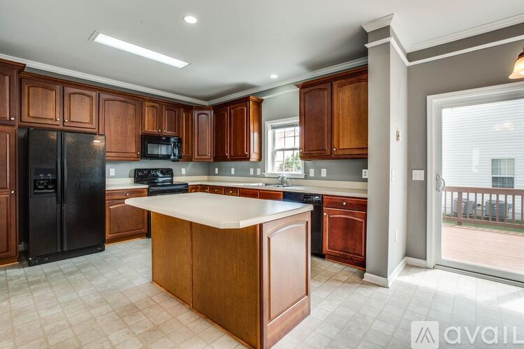 A kitchen with wooden cabinets and a black refrigerator.