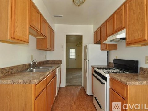A kitchen with wooden cabinets and a white refrigerator.