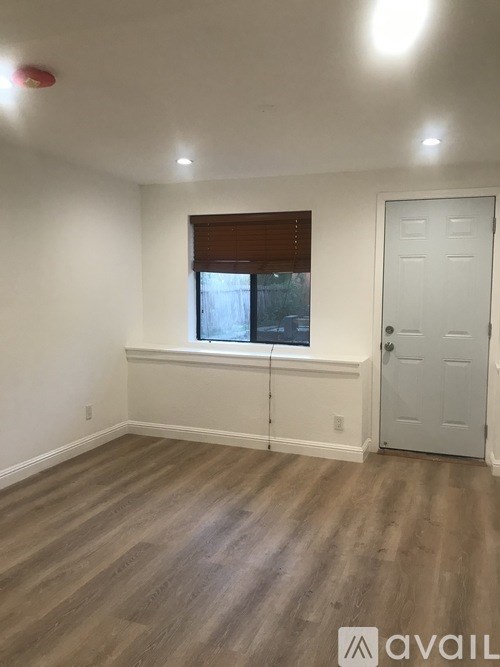 A room with a white door and a window with blinds.