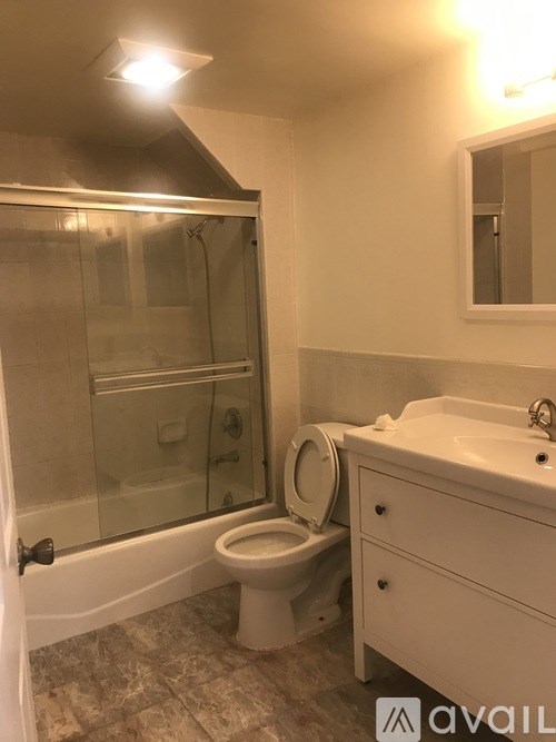 A bathroom with a toilet, sink, and shower.
