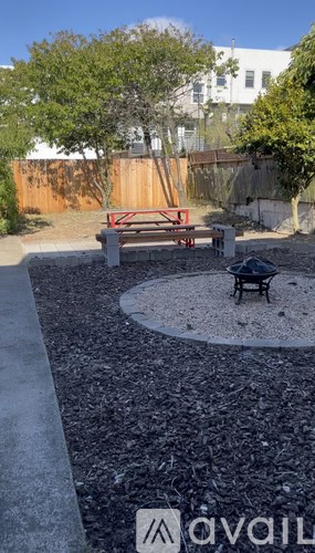 A backyard with a bench and a fire pit.
