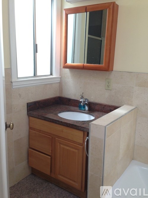 A bathroom with a sink and a mirror above it.