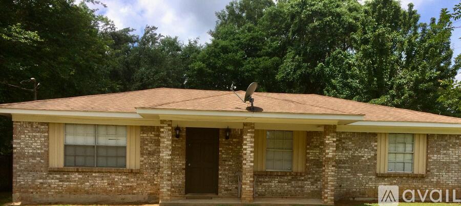 A house with a brown roof and a sign that says "AVAIL" in front of it.