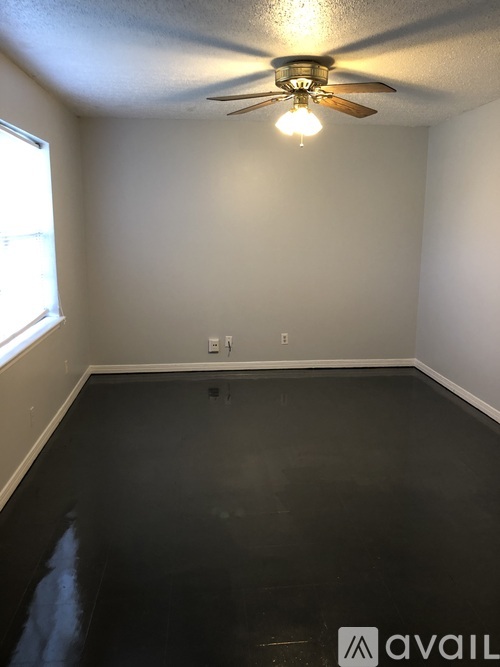 A room with a ceiling fan and a window.