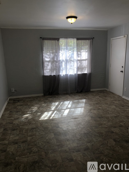 A room with a tiled floor and a window with curtains.