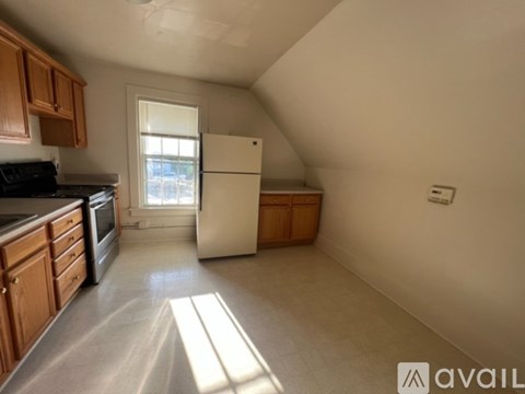 A kitchen with wooden cabinets and a white refrigerator.