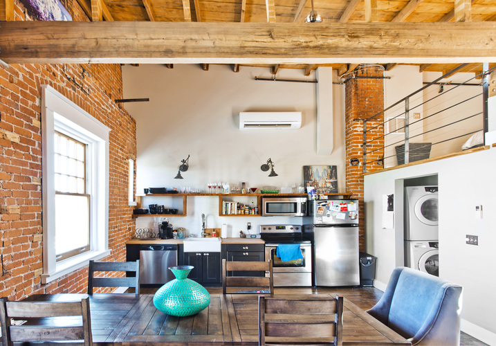 A kitchen with a table and chairs in front of it.